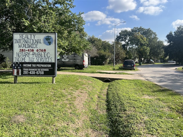 community / neighborhood sign featuring a yard