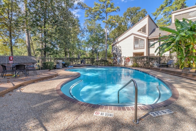 view of swimming pool with a deck and a patio