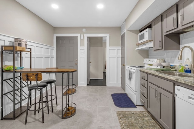 kitchen featuring gray cabinetry, white appliances, sink, and light tile patterned floors