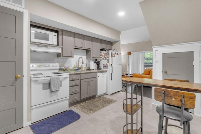 kitchen featuring gray cabinetry, sink, exhaust hood, and white appliances