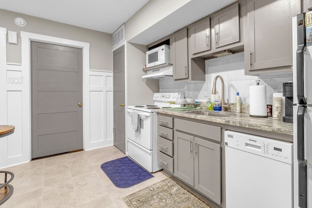 kitchen featuring gray cabinetry, decorative backsplash, sink, and white appliances