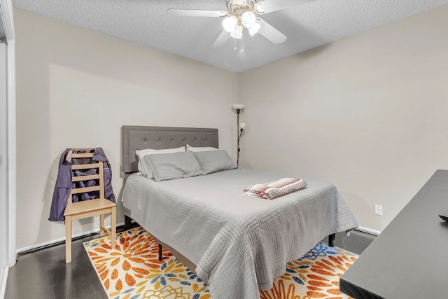 bedroom featuring ceiling fan, a textured ceiling, and a baseboard heating unit