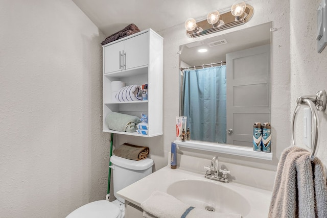 bathroom featuring vanity and toilet