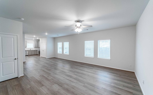 unfurnished living room featuring light hardwood / wood-style flooring and ceiling fan