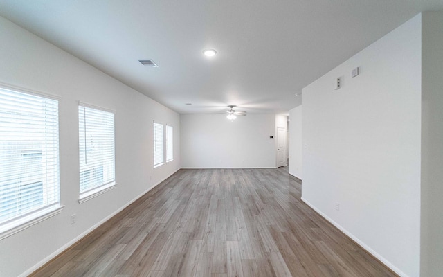 empty room with ceiling fan and light hardwood / wood-style flooring