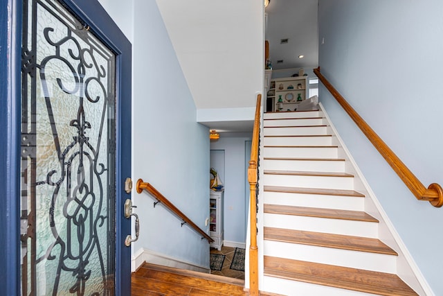 staircase with hardwood / wood-style floors