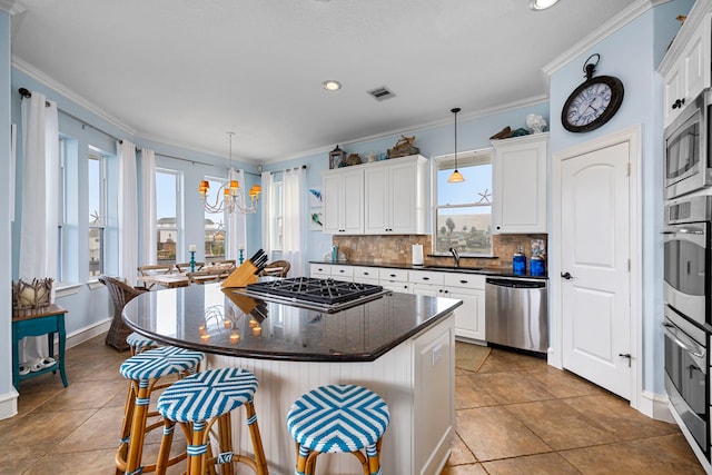 kitchen with white cabinetry, appliances with stainless steel finishes, and hanging light fixtures