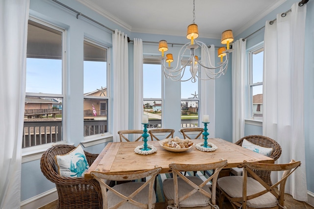 dining area with crown molding, an inviting chandelier, and a wealth of natural light