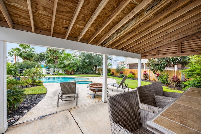 view of patio featuring an outdoor fire pit and a fenced in pool