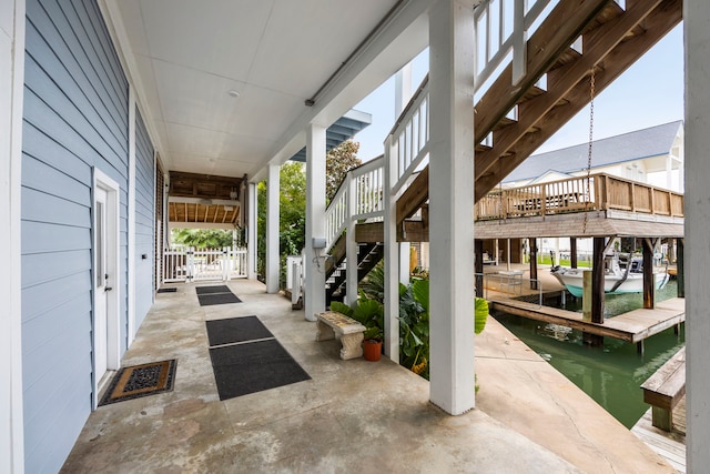 view of patio featuring a water view and a dock