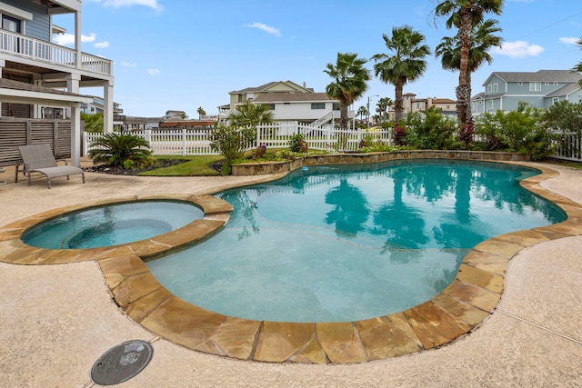 view of swimming pool with an in ground hot tub