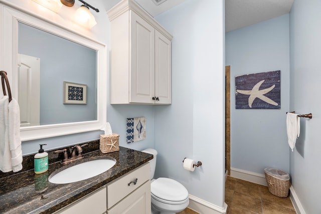 bathroom featuring tile patterned floors, vanity, and toilet