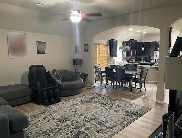 living room featuring hardwood / wood-style floors and ceiling fan with notable chandelier