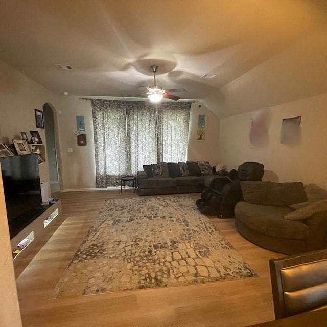 living room featuring wood-type flooring, ceiling fan, and vaulted ceiling