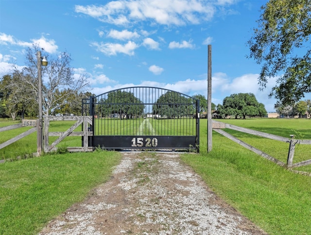 view of gate with a lawn