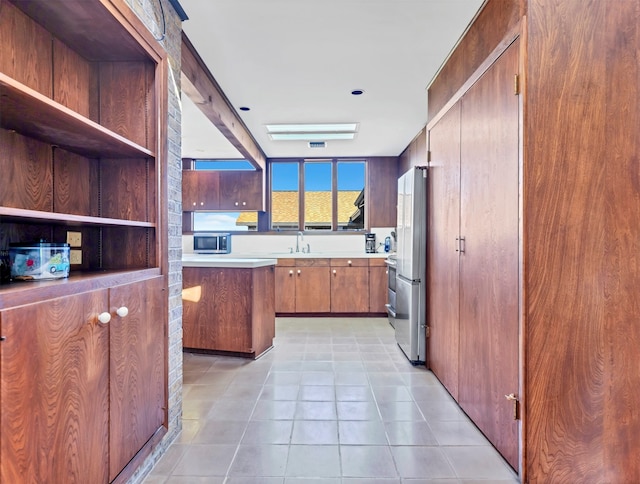 kitchen with light tile floors, appliances with stainless steel finishes, and sink