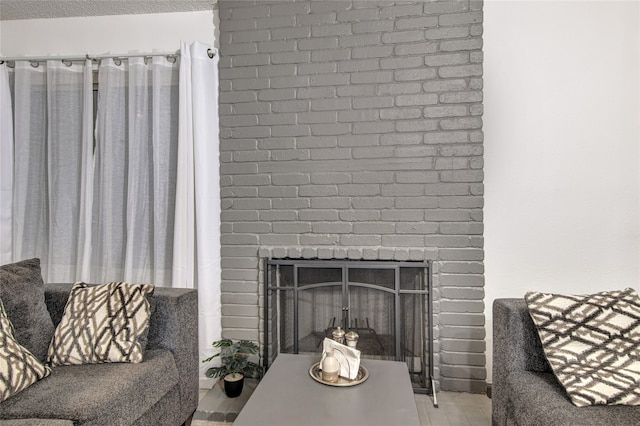 living room with a brick fireplace and wood-type flooring