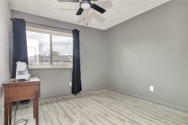 spare room featuring a textured ceiling, ceiling fan, and light wood-type flooring