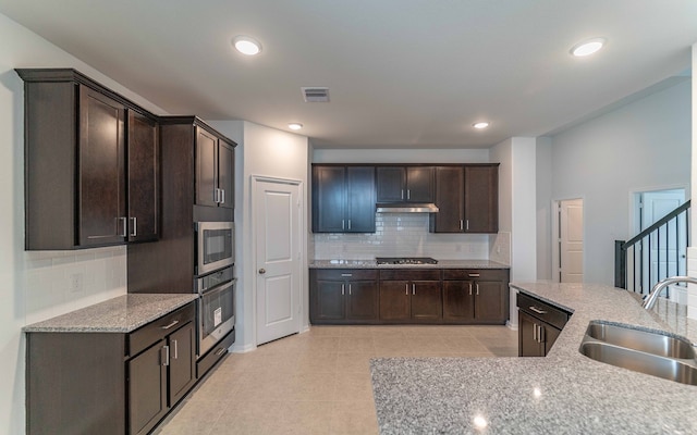 kitchen with sink, light tile floors, backsplash, and appliances with stainless steel finishes