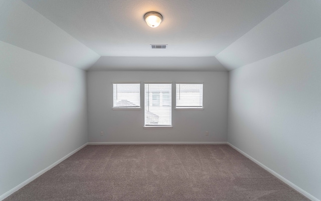 empty room with lofted ceiling and carpet floors