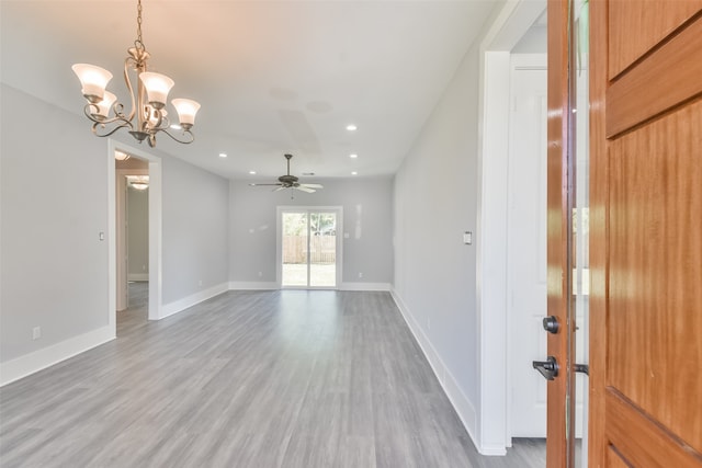 unfurnished room featuring ceiling fan with notable chandelier and wood-type flooring