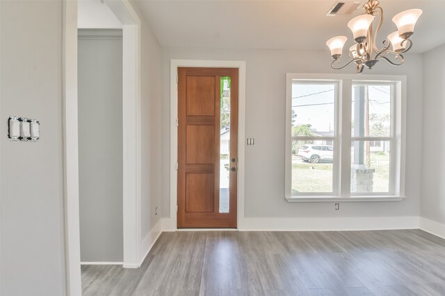 foyer entrance with light wood-type flooring and a chandelier