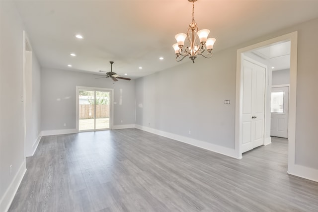 spare room with ceiling fan with notable chandelier and hardwood / wood-style floors