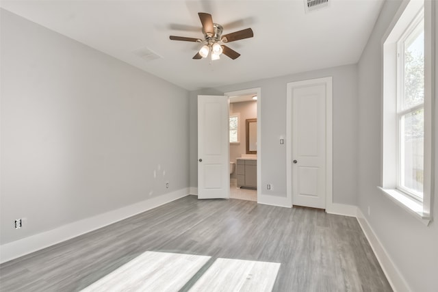 unfurnished bedroom featuring ceiling fan, connected bathroom, and light hardwood / wood-style floors