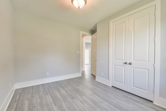 unfurnished bedroom featuring a closet and light hardwood / wood-style flooring