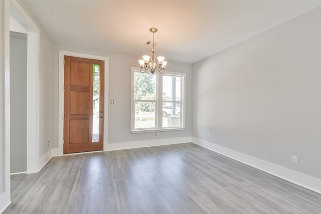 foyer entrance with light hardwood / wood-style floors and a chandelier