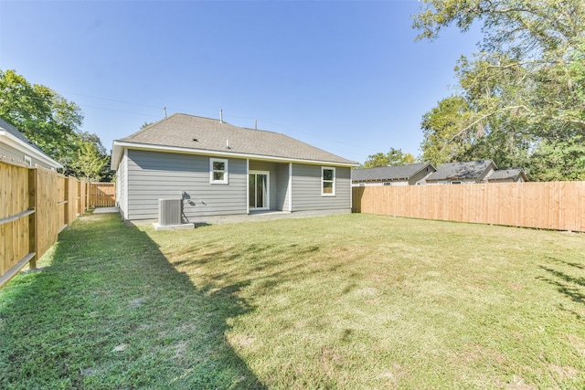 rear view of property featuring cooling unit, a yard, and a patio area