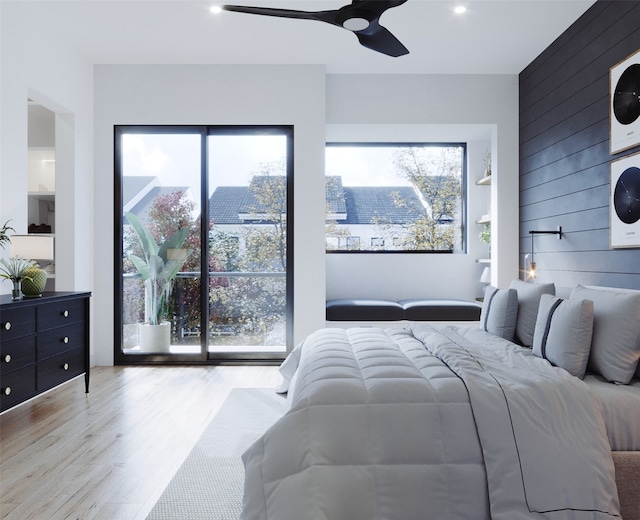 bedroom with wood walls, ceiling fan, and light hardwood / wood-style flooring