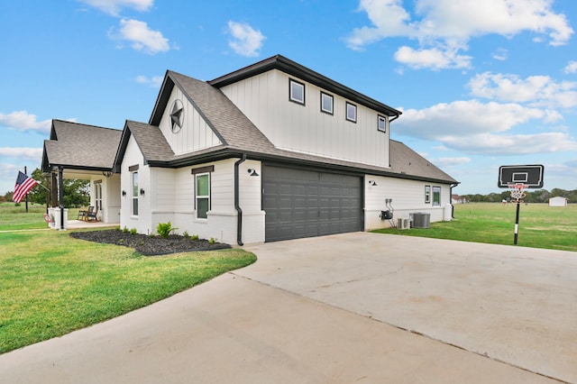 view of front of property with a front lawn, central air condition unit, and a garage