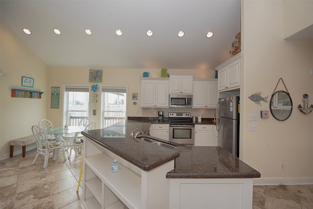 kitchen featuring white cabinets, stainless steel appliances, light tile floors, sink, and dark stone counters