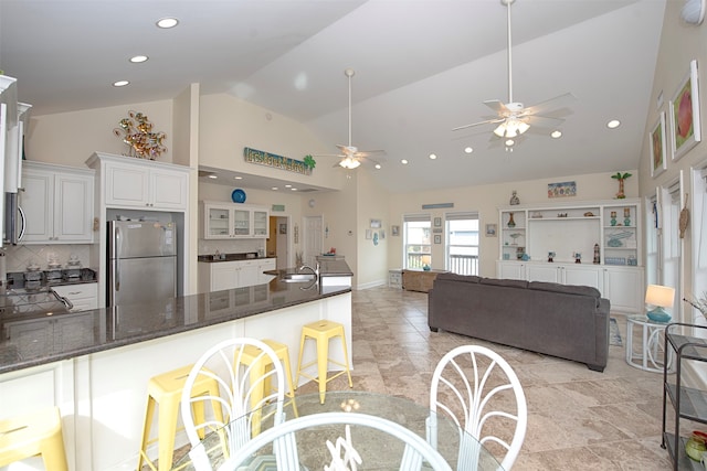 kitchen featuring backsplash, ceiling fan, stainless steel appliances, white cabinets, and light tile floors