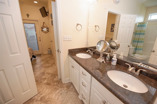 bathroom with dual bowl vanity, toilet, and tile floors