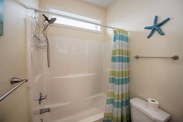 bathroom with shower / bath combination with curtain and toilet