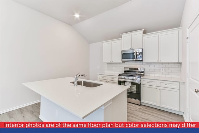 kitchen featuring appliances with stainless steel finishes, sink, an island with sink, light hardwood / wood-style flooring, and white cabinets