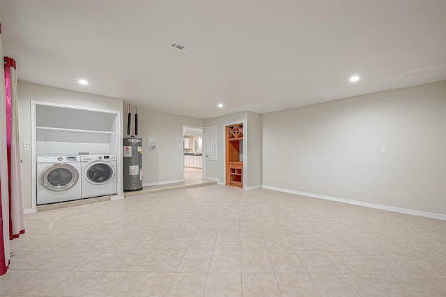 washroom featuring electric water heater and washer and clothes dryer