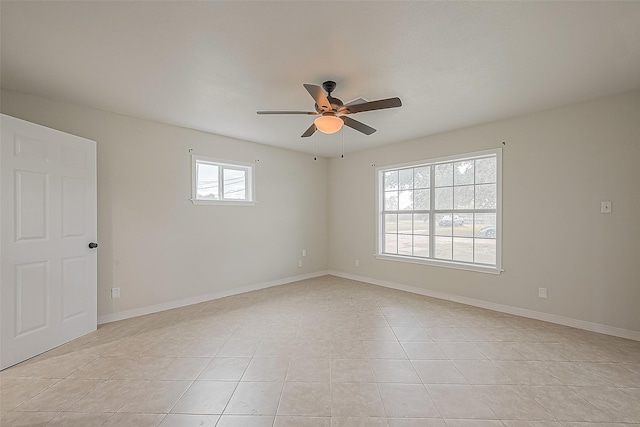 tiled empty room featuring ceiling fan