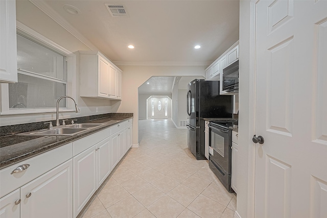 kitchen featuring sink, light tile patterned floors, black appliances, and white cabinetry