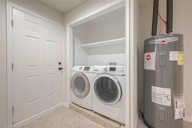 clothes washing area with water heater, washer and dryer, and light tile patterned floors