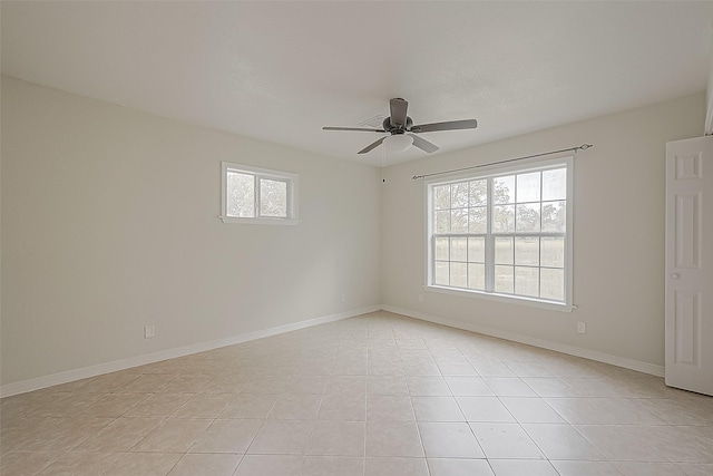 empty room with ceiling fan and light tile patterned floors