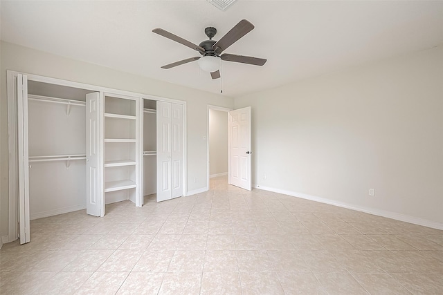 unfurnished bedroom featuring two closets, ceiling fan, and light tile patterned floors