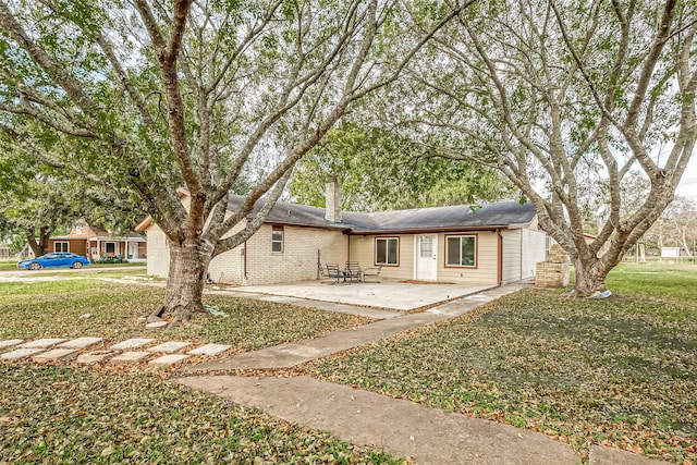 view of front of house with a patio area and a front yard