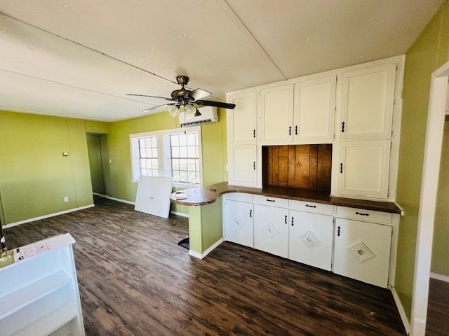 kitchen featuring ceiling fan, dark hardwood / wood-style flooring, white cabinetry, and a wall mounted air conditioner