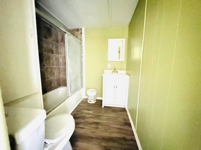 full bathroom featuring toilet, vanity, hardwood / wood-style flooring, and shower / bath combination with glass door