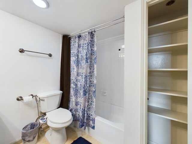 bathroom featuring tile floors, toilet, and shower / tub combo with curtain