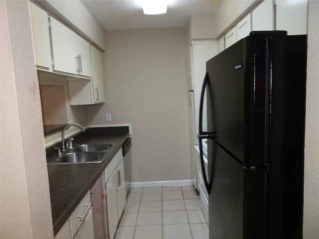 kitchen featuring black refrigerator, sink, light tile patterned floors, dishwasher, and white cabinets