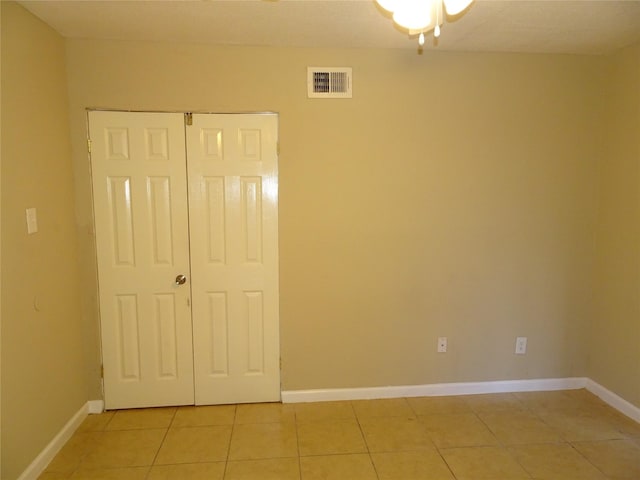 unfurnished bedroom with a closet and light tile patterned floors